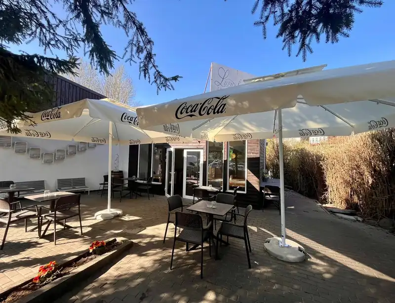 Ogródek z parasolami i stolikami przed restauracją